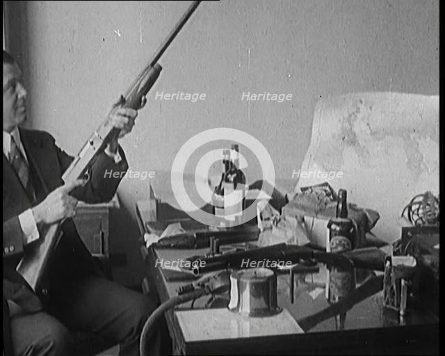 Male Detective Showing off Smugglers' Captured Guns, 1929.  Creator: British Pathe Ltd.