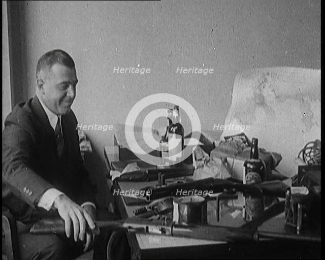 Male Detective Showing off Smugglers' Captured Guns, 1929.  Creator: British Pathe Ltd.