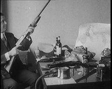 Male Detective Showing off Smugglers Captured Guns, 1929. Creator: British Pathe Ltd