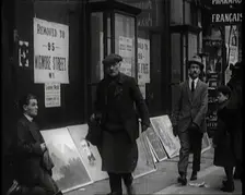 Male Ex-Services Civilian Selling Paintings on a Pavement Whilst Other Civilians are Walk..., 1920s. Creator: British Pathe Ltd