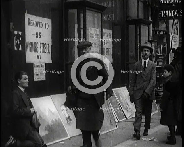 Male Ex-Services Civilian Selling Paintings on a Pavement Whilst Other Civilians are Walk..., 1920s. Creator: British Pathe Ltd.