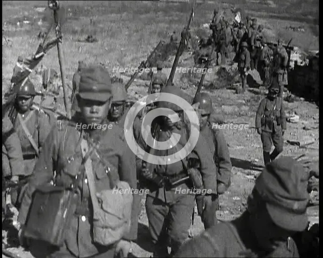 Male Japanese Soldiers With Rifles Walking up a Hillside, Near the City of Hankow, 1937.  Creator: British Pathe Ltd.