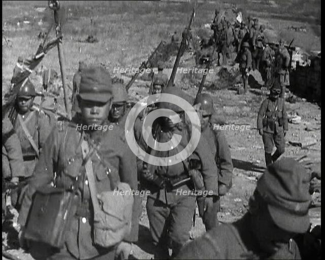 Male Japanese Soldiers With Rifles Walking up a Hillside, Near the City of Hankow, 1937.  Creator: British Pathe Ltd.