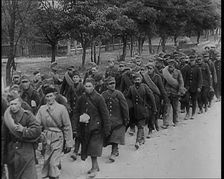 Male Polish Soldiers Walking Along an Unpaved Road Beside a Line of Trees With Fences Beyond, 1939. Creator: British Pathe Ltd