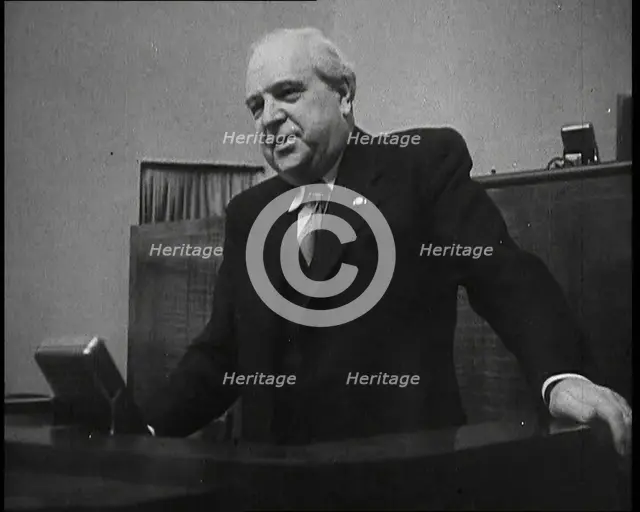 Male Representative of the League of Nations Speaking at Lectern in Front of Microphone, 1937. Creator: British Pathe Ltd.