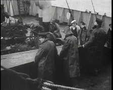 Male Ship's Crew Standing Near Rigging and Machinery on Deck of a Freighter, 1939. Creator: British Pathe Ltd