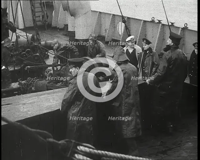 Male Ship's Crew Standing Near Rigging and Machinery on Deck of a Freighter, 1939. Creator: British Pathe Ltd.