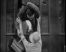 Male Soldier Kissing Female Civilian from the Window of a Train, 1929. Creator: British Pathe Ltd