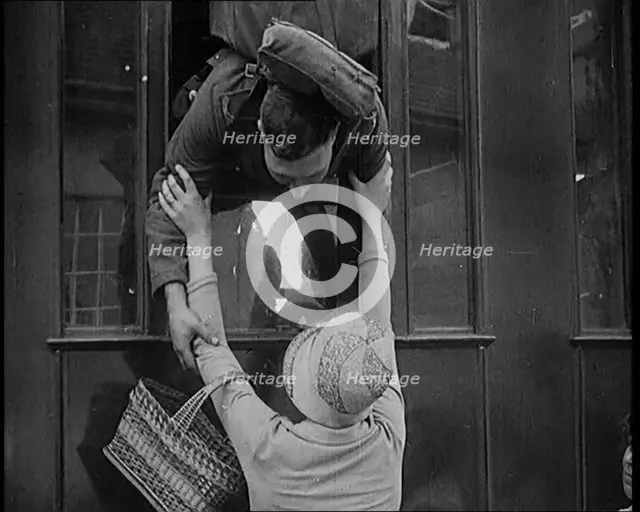 Male Soldier Kissing Female Civilian from the Window of a Train, 1929. Creator: British Pathe Ltd.