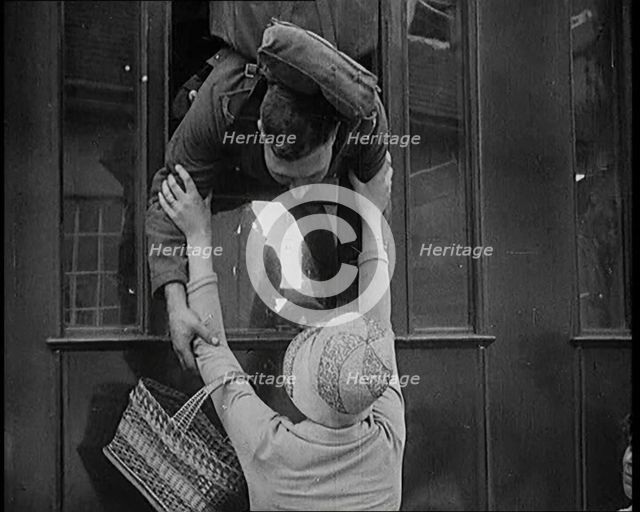 Male Soldier Kissing Female Civilian from the Window of a Train, 1929. Creator: British Pathe Ltd.