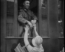 Male Soldier Kissing Female Civilian from the Window of a Train, 1929. Creator: British Pathe Ltd
