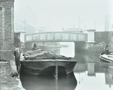 Man mooring a barge by a river bank, Poplar, London, 1905