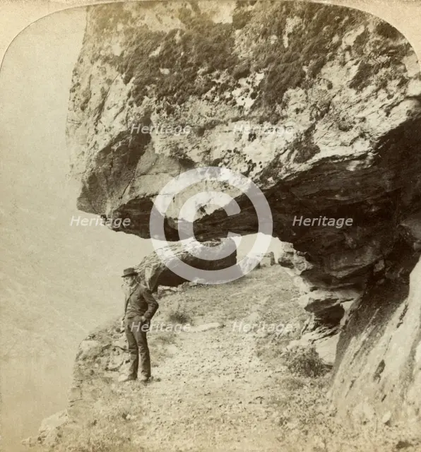 Man on a cliff overlooking Naeroyfjord, Sogne, Norway. Creator: Bert Underwood.