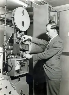 Man operating film projector, c1955. Creator: Arthur Charles Kirby Ware
