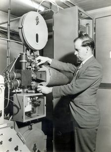 Man operating film projector, c1955. Creator: Arthur Charles Kirby Ware