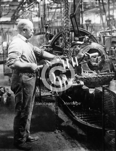 Man operating machinery in a car factory. Artist: Unknown