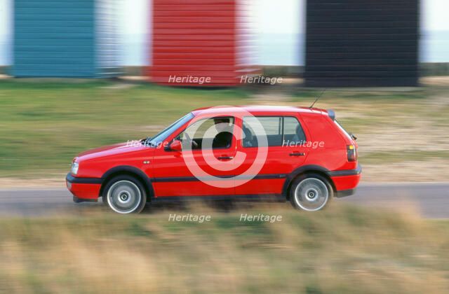 Man driving 1996 Vokswagen Golf Gti. Artist: Unknown.