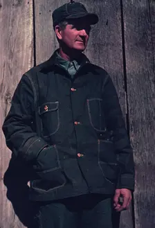 Man in bill cap and dungaree coat, possibly a farmer, between 1941 and 1942. Creator: Unknown