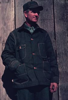 Man in bill cap and dungaree coat, possibly a farmer, between 1941 and 1942. Creator: Unknown