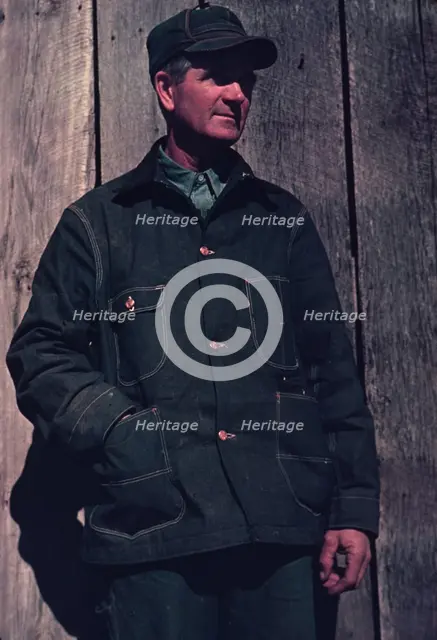 Man in bill cap and dungaree coat, possibly a farmer, between 1941 and 1942. Creator: Unknown.