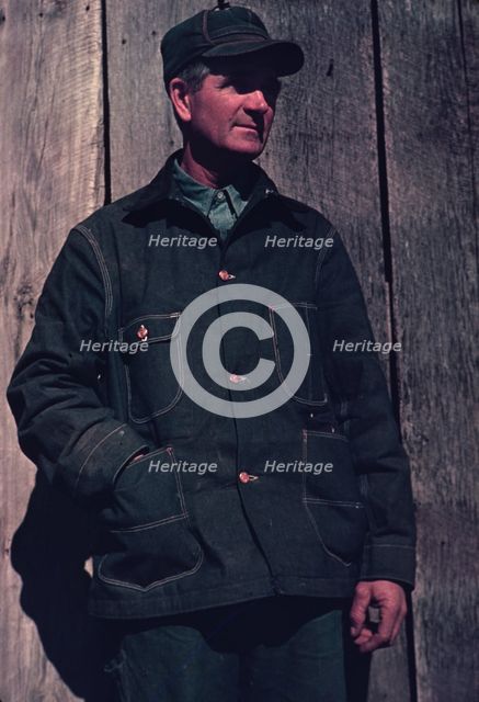 Man in bill cap and dungaree coat, possibly a farmer, between 1941 and 1942. Creator: Unknown.