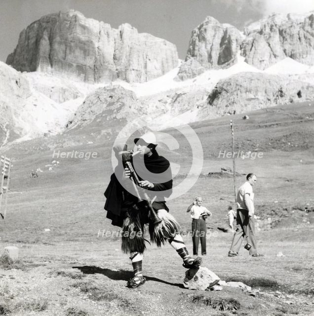 Man in traditional costume playing the zampogna (bagpipes), Sasso Pordoi, Dolomites, Italy, c1955. Creator: Arthur Charles Kirby Ware.