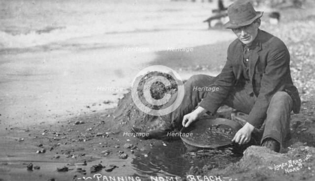 Man panning gold on Nome Beach, between c1900 and c1930. Creator: Lomen Brothers.