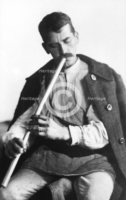 Man playing a wind instrument, Bistrita Valley, Moldavia, north-east Romania, c1920-c1945. Artist: Adolph Chevalier