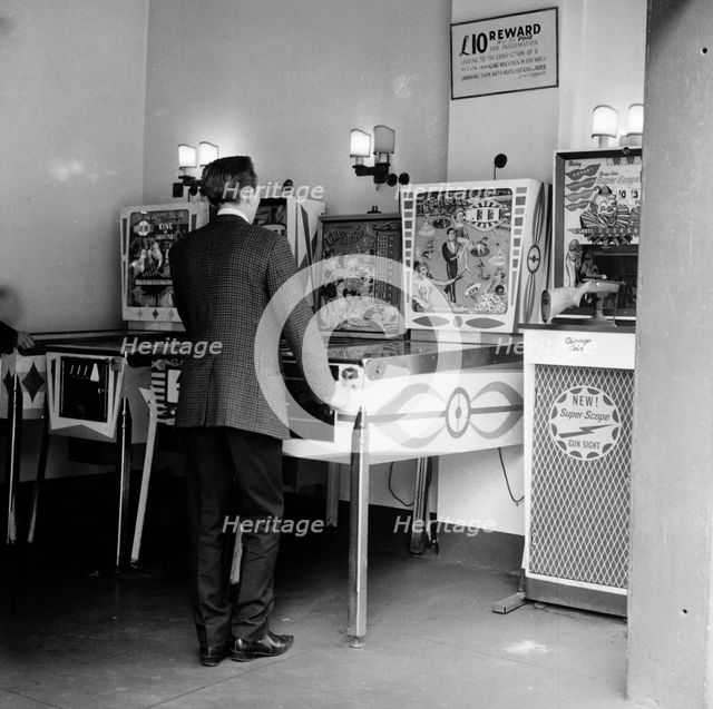 Man playing pinball in a London amusement arcade, c1966-67. Creator: Henry Grant.