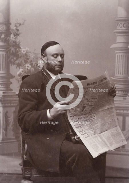 Man reading a newspaper with a long pipe in his hand, Landskrona, Sweden, 1910. Artist: Unknown