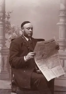 Man reading a newspaper with a long pipe in his hand, Landskrona, Sweden, 1910. Creator: Unknown