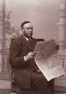 Man reading a newspaper with a long pipe in his hand, Landskrona, Sweden, 1910. Creator: Unknown