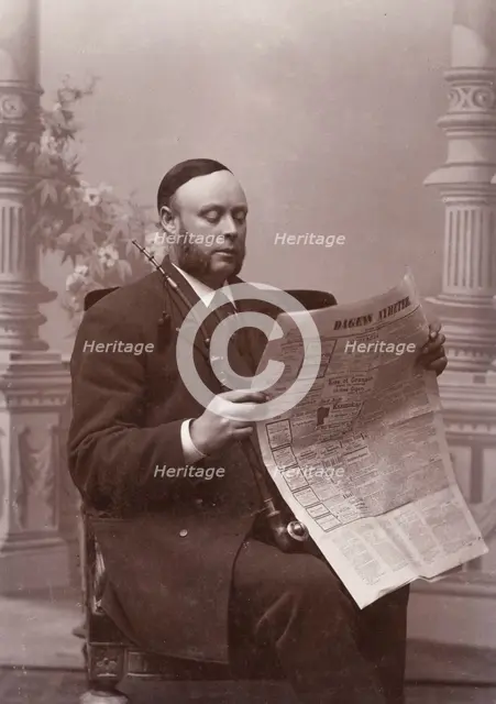 Man reading a newspaper with a long pipe in his hand, Landskrona, Sweden, 1910. Creator: Unknown.
