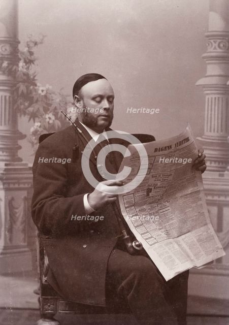 Man reading a newspaper with a long pipe in his hand, Landskrona, Sweden, 1910. Creator: Unknown.