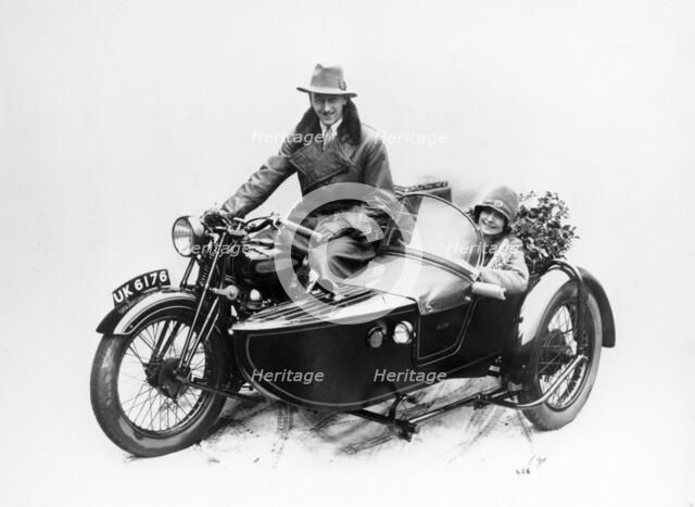 Man riding an AJS motorbike with a woman in the sidecar, 1939. Artist: Unknown