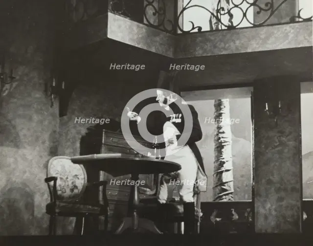 Man standing by table, 1938. Creator: Unknown.