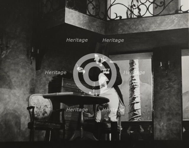 Man standing by table, 1938. Creator: Unknown.