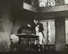 Man standing by table, 1938. Creator: Unknown
