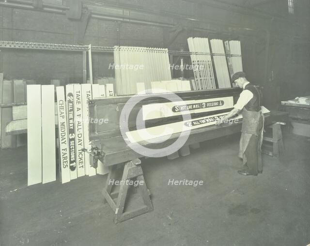 Man stencilling signs for tram cars at Charlton Central Repair Depot, London, 1932. Artist: Unknown.
