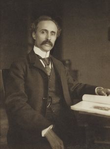 Man seated with table and book, 1896-1898. Creator: Gertrude Kasebier
