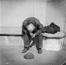Man seated on a stone bench on Blackfriars Bridge, London, c1946-c1959. Artist: John Gay