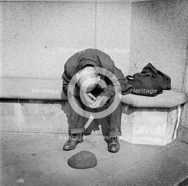 Man seated on a stone bench on Blackfriars Bridge, London, c1946-c1959. Artist: John Gay