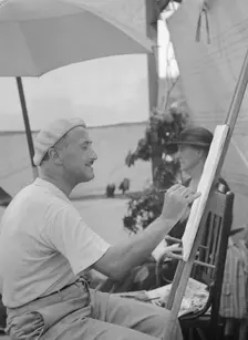 Man seated outdoors painting, East Hampton, Long Island, between 1933 and 1942. Creator: Arnold Genthe