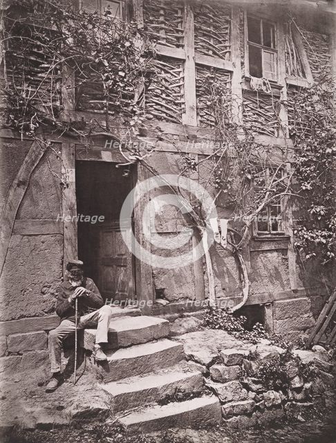 [Man Sitting on Steps of House with Socks Hanging on Nearby Vine to Dry], 1880s. Creator: Unknown.