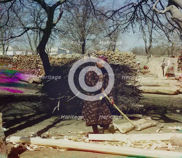 Man using tool to strip logs, Central Asia?, between 1905 and 1915. Creator: Sergey Mikhaylovich Prokudin-Gorsky.