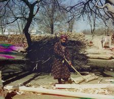 Man using tool to strip logs, Central Asia?, between 1905 and 1915. Creator: Sergey Mikhaylovich Prokudin-Gorsky