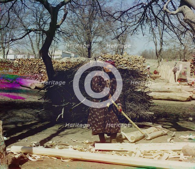 Man using tool to strip logs, Central Asia?, between 1905 and 1915. Creator: Sergey Mikhaylovich Prokudin-Gorsky.
