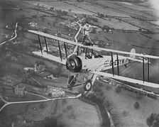 Man wing walking on an Avro 504 biplane without a harness, 20th century. Artist: Aerofilms
