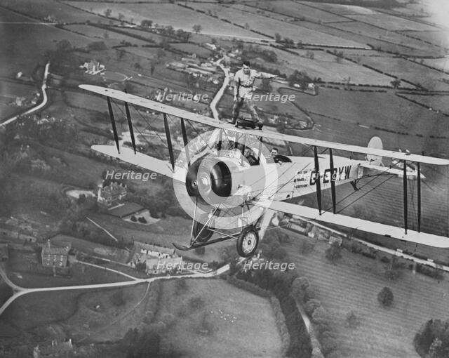 Man wing walking on an Avro 504 biplane without a harness, 20th century. Artist: Aerofilms.