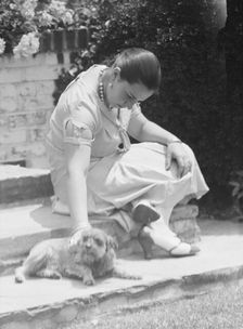 Manship, Pauline, Miss, with dog, seated outdoors, 1931 June 14. Creator: Arnold Genthe